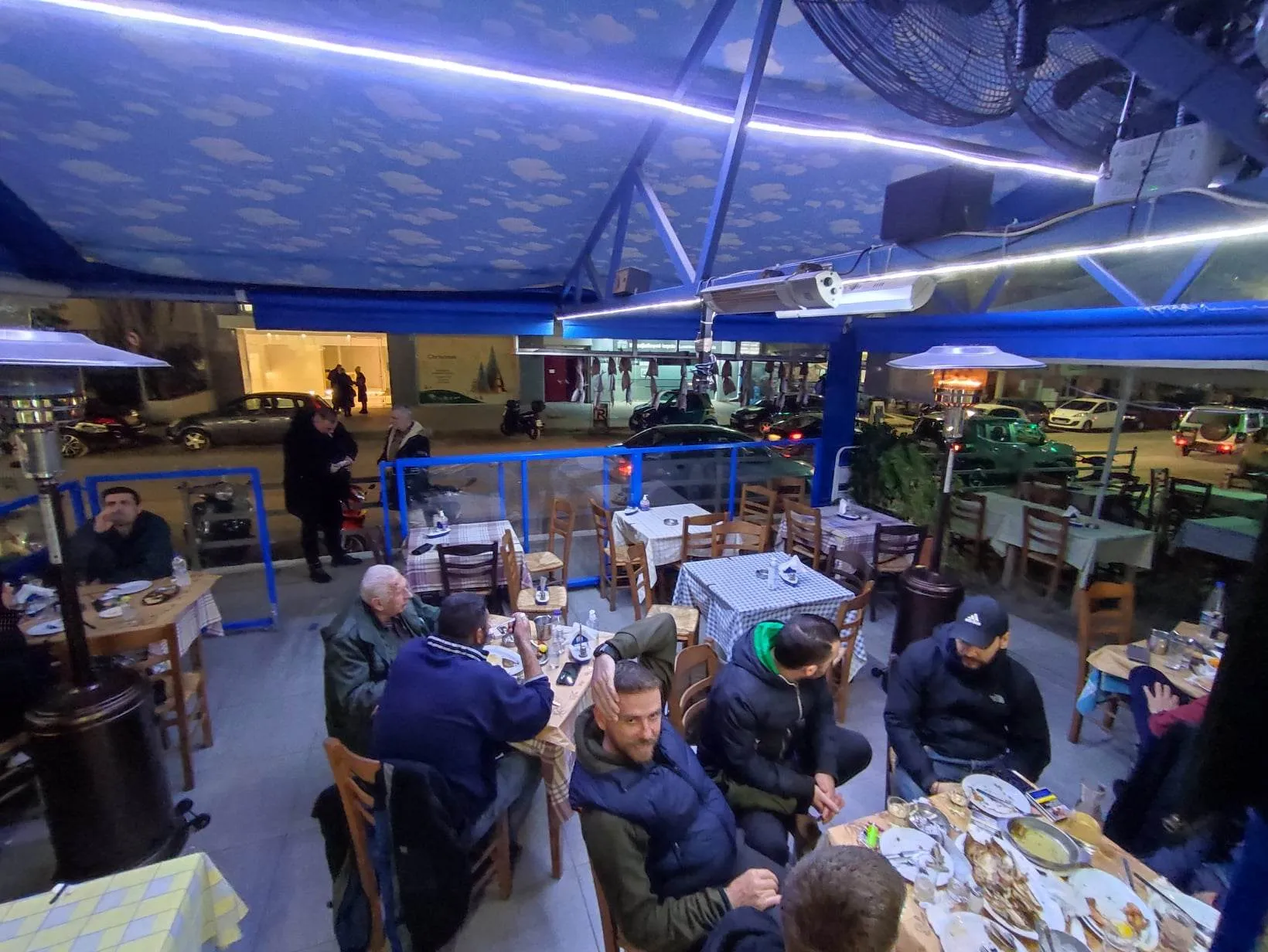 Η βεράντα το βράδυ, με τα τραπέζια γεμάτα